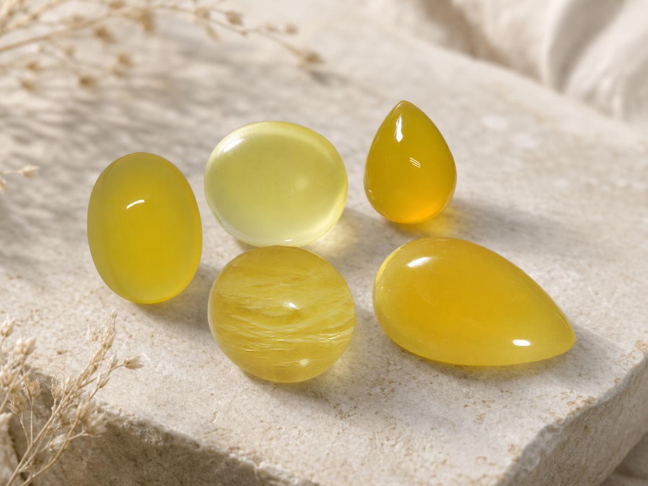 Assorted loose yellow cabochon gemstones in warm golden tones